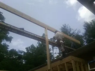 Carpenter setting a ridge beam over a new addition frame in Campbelltown