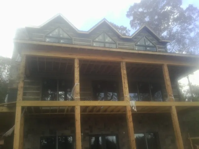 Dormers and porch framing on a large log home under construction — Roof Coating work by our crew in Campbelltown
